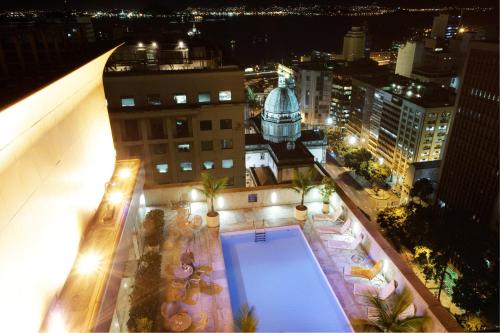 里约热内卢Windsor Guanabara Hotel的享有带游泳池的大楼的顶部景致