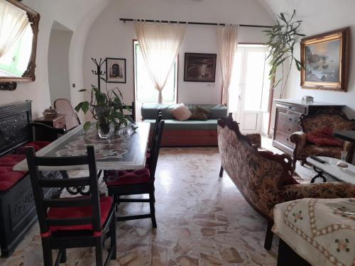 普罗奇达La Casa di Romeo的客厅配有桌椅和沙发