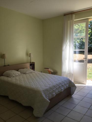 贝尔热拉克La Sabatière的一间卧室设有一张床和一个滑动玻璃门