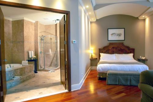 布罗瑟德布罗萨德酒店的一间卧室配有一张床、淋浴和浴缸