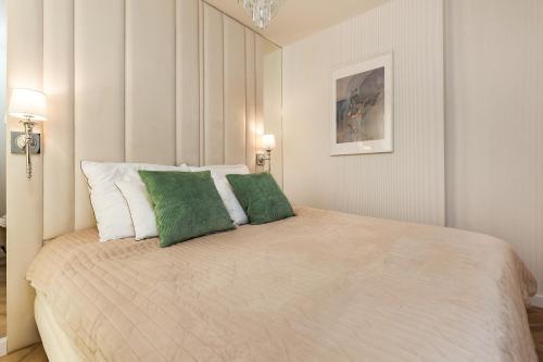 格但斯克LuxApart Gdańsk的一间卧室配有一张大床和两个绿色枕头