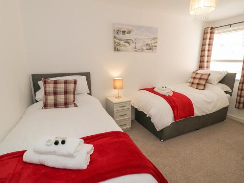 本莱赫Benllech Coastal Retreat的一间卧室配有两张带毛巾的床