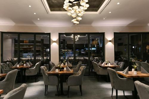维尔茨堡Boutique Hotel Canel的一间带桌椅和吊灯的餐厅