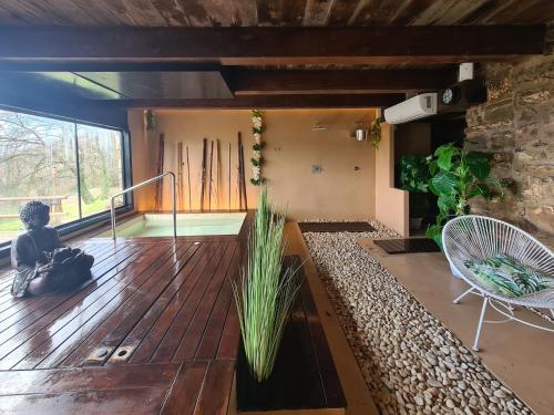 Vall de Bianya马斯普拉特乡村Spa酒店的客房设有带椅子的木制甲板和窗户。