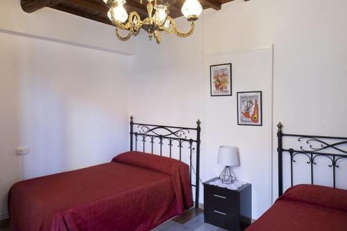 ArmarizA Pousa Pensión rural (Camino de Santiago Sanabrés)的一间卧室配有两张带红色床单和吊灯的床。