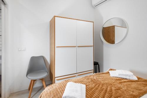 马德里Minty Stay - Hortaleza Studio的一间卧室配有镜子、一张床和一把椅子