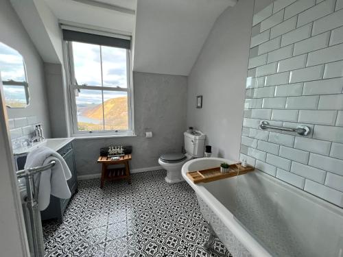 拉尼德洛伊斯Ty Capel的带浴缸、卫生间和窗户的浴室