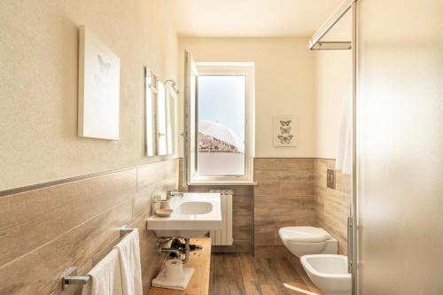 西尔米奥奈比安卡住宅酒店的一间带水槽和卫生间的浴室以及窗户。
