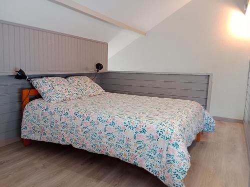 康庞Gîte cosy Lac de Payolle的一间卧室配有一张带花卉床罩的床