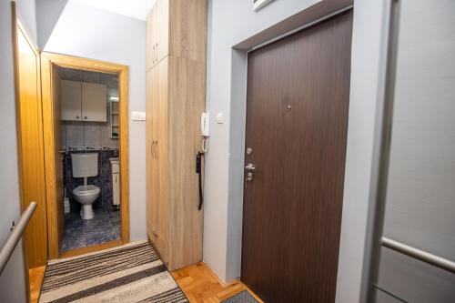 采蒂涅Apartment Sole的一间带卫生间和木门的浴室
