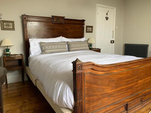 海斯廷斯Gloucester House的一间卧室配有一张大木床和白色床单