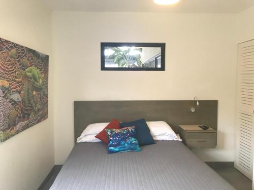 Playa PanamaBungle in the Jungle的卧室配有一张床,墙上挂着一幅画