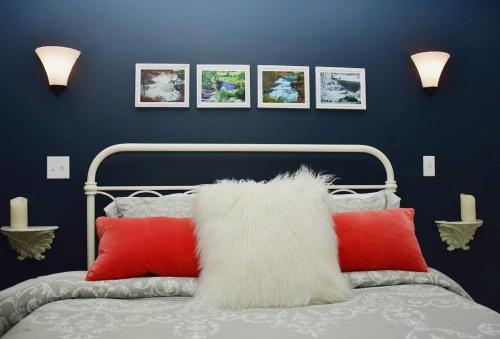 沃威克Cottage at Millpond Falls - A Romantic Escape的一间卧室配有红色和白色枕头的床