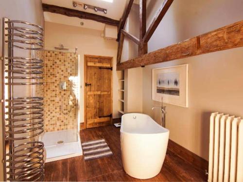 克罗姆福德The Malthouse的大型浴室设有浴缸和淋浴。