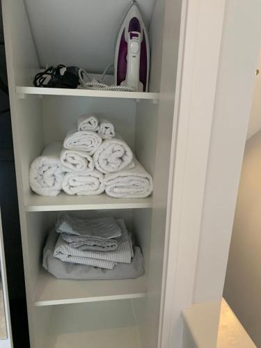 多尔金Cosy Beautiful One bedroom Flat的衣柜里备有毛巾和一堆毛巾