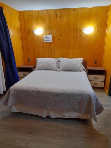 普孔nancy的一间卧室配有一张带木墙的大床