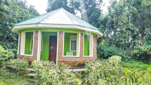 KisoroAmajambere Iwacu Community Camp的花园中带门的小绿色房子