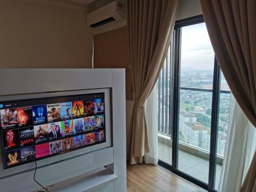 史里肯邦安Apple Home 1 @ Menara Simfoni/Symphony Tower C180/Cheras/Mines/Balakong/Kuala Lumpur的配有大窗户的客房内的平面电视