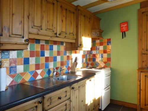 EyeriesSugarbush的厨房设有水槽,墙上铺有色彩缤纷的瓷砖。