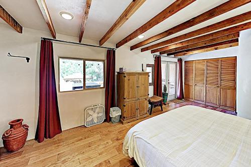 陶斯Valverdo Oasis的一间卧室设有一张大床和木制天花板。