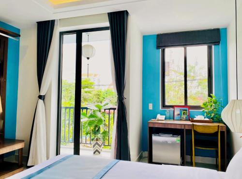 会安Grand Holiday Hoian Villa的卧室配有一张床、一张书桌和窗户。