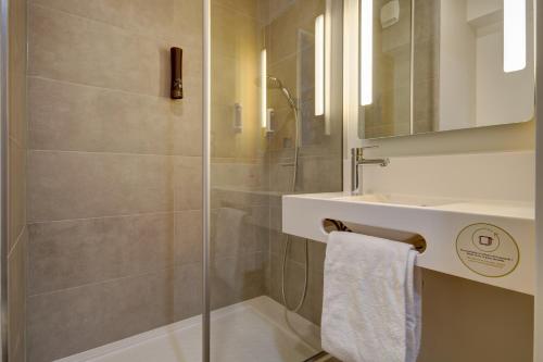 埃佩尔奈B&B HOTEL Epernay的带淋浴、盥洗盆和镜子的浴室