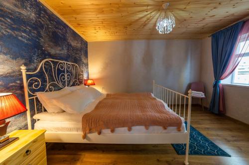 Dedoplis TskaroSavanna Guest House的卧室配有白色床和木制天花板
