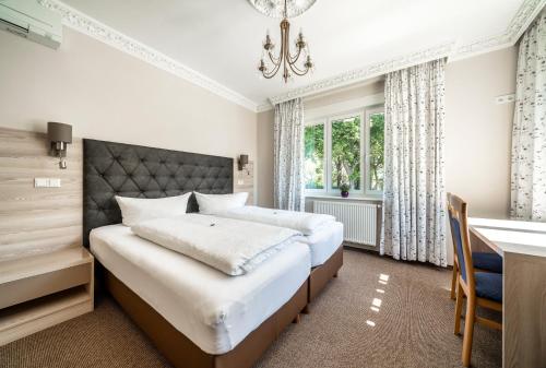 德累斯顿瓦德斯罗斯琛别墅酒店的一间卧室配有一张床、一张书桌和一张书桌