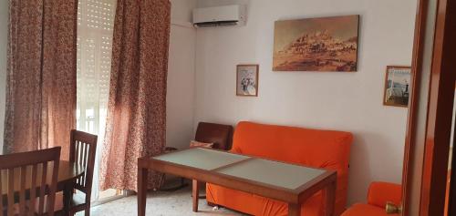加的斯Playa La Caleta La Viña Cadiz PLAZA GARAJE GRATIS的客厅配有橙色椅子和桌子