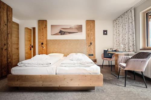 圣加伦基希Hotel Alpenfeuer Montafon的一间卧室配有两张床和一张书桌