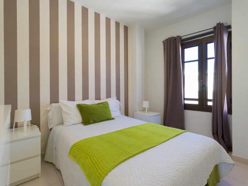 阿雷西费Mahostly Apartamento Comillas SC的一间卧室配有一张带绿毯的床和窗户。