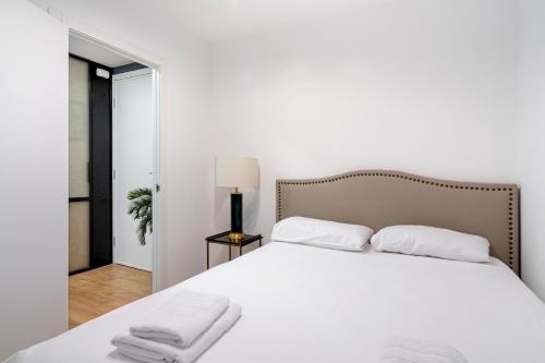 马德里3 bedrooms 2 bathrooms furnished - Salamanca - Stylish - MintyStay的卧室配有白色床和毛巾