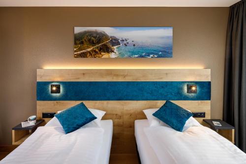 苏黎世加利福尼亚酒店的酒店客房 - 带两张带蓝色枕头的床