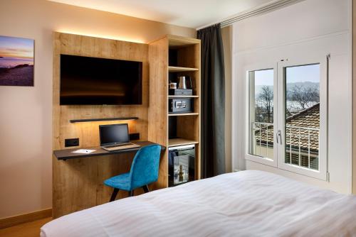 苏黎世加利福尼亚酒店的一间卧室配有一张床和一张带电脑的书桌