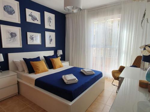莫哈卡尔Marina Golf Mojacar Playa的一间卧室配有一张蓝色墙壁的床和一扇窗户