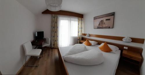 考那亚诺Landhaus Weingut的一间卧室配有带白色床单和橙色枕头的床。