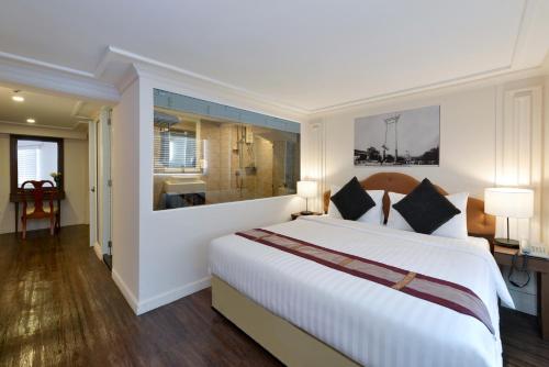 曼谷暹罗香榭丽舍大街特色酒店的一间带白色大床的卧室和一间浴室