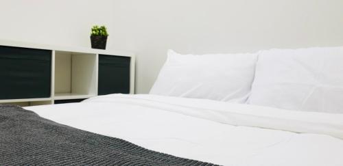 马尼拉S Residences-MOA的白色的床单和盆栽植物