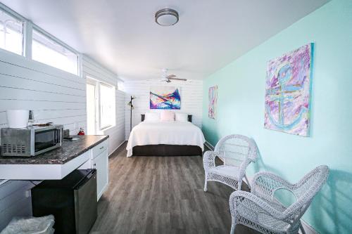伊斯拉莫拉达Drop Anchor Resort & Marina的一间卧室配有一张床和两把椅子
