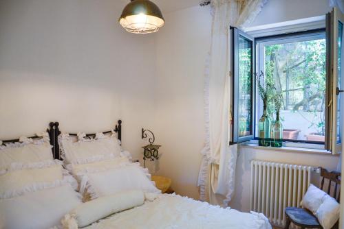 法萨诺Cortebbianca的卧室配有带白色枕头的床和窗户。