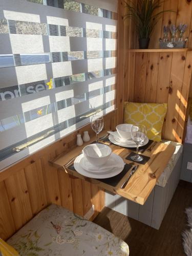 普里茅斯Shepherd's Hut at St Anne's - Costal Location的一张桌子上放有盘子和酒杯