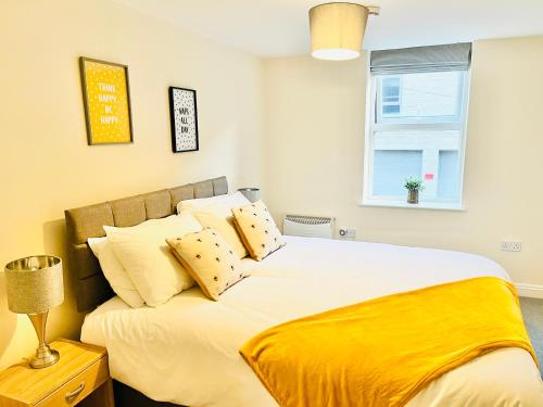 伊尔克利Ilkley Apartment with Parking的一间卧室配有一张带黄色床单的大床和窗户。