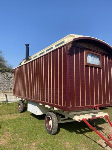 普里茅斯Vintage Showman's Wagon For Two Close to Beach的一辆坐于草地上的火车车厢