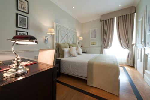 维罗纳Hotel Bologna ***S的一间卧室配有一张床和一张带台灯的书桌