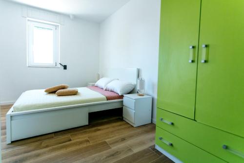 马蒂纳塔Gargano Country House I的一间卧室配有一张带绿色橱柜的床