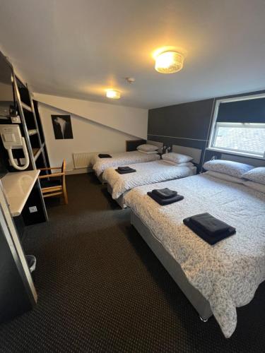 泰恩河畔纽卡斯尔布莱顿酒店的一间设有三张床的客房,备有毛巾