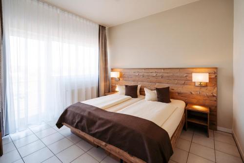 GensingenHotel Café Nahetal - Hotel garni的一间卧室设有一张床和一个大窗户