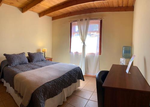 圣佩德罗·德·阿塔卡马Sami Atacama的一间卧室设有一张床和一个窗口