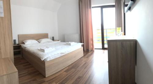 GreciPlai Dobrogean的一间卧室设有一张床和一个大窗户