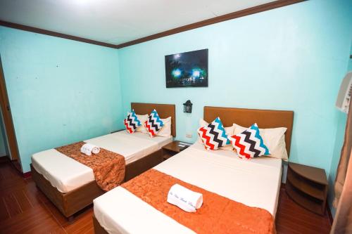 CandelariaIsla Vista Beach Resort的蓝色墙壁客房的两张床